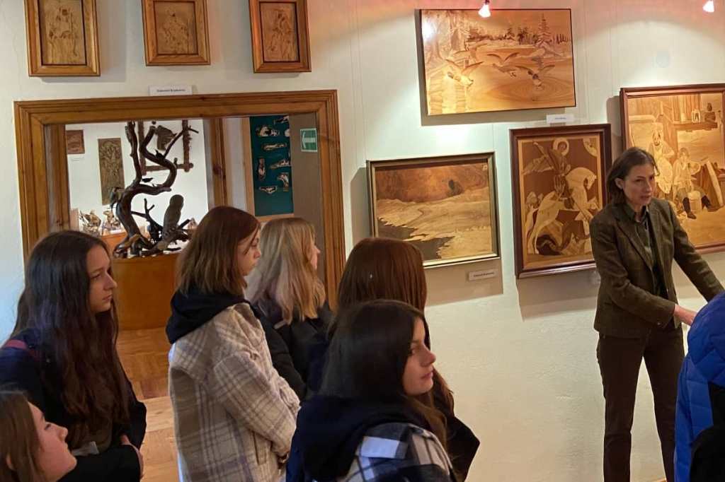 Na zdjęciu grupa uczniów w gołuchowskim muzeum leśnictwa. Uczniowie słuchają przewodnika prezentującego eksponaty na znajdujące się na wystawie.