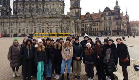 Uczniowie podczas wycieczki do Drezna, pozują do zdjęcia na placu, na tle zamku.