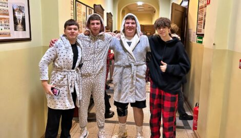 Na zdjęciu uczniowie na szkolnym korytarzu, ubrani w piżamy z okazji dnia piżamy.