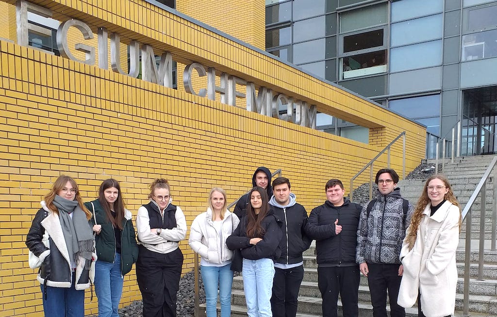 Na zdjęciu grupa uczniów na tle budynku Wydziału Chemii na Uniwersytecie im. Adama Mickiewicza w Poznaniu.