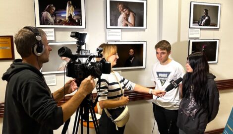 Dwójka uczniów udziela wywiadu lokalnej telewizji, podczas otwarcia wystawy fotograficznej w urzędzie miasta w Pleszewie.