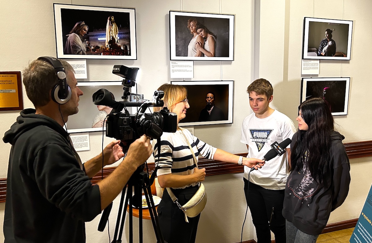 Dwójka uczniów udziela wywiadu lokalnej telewizji, podczas otwarcia wystawy fotograficznej w urzędzie miasta w Pleszewie.