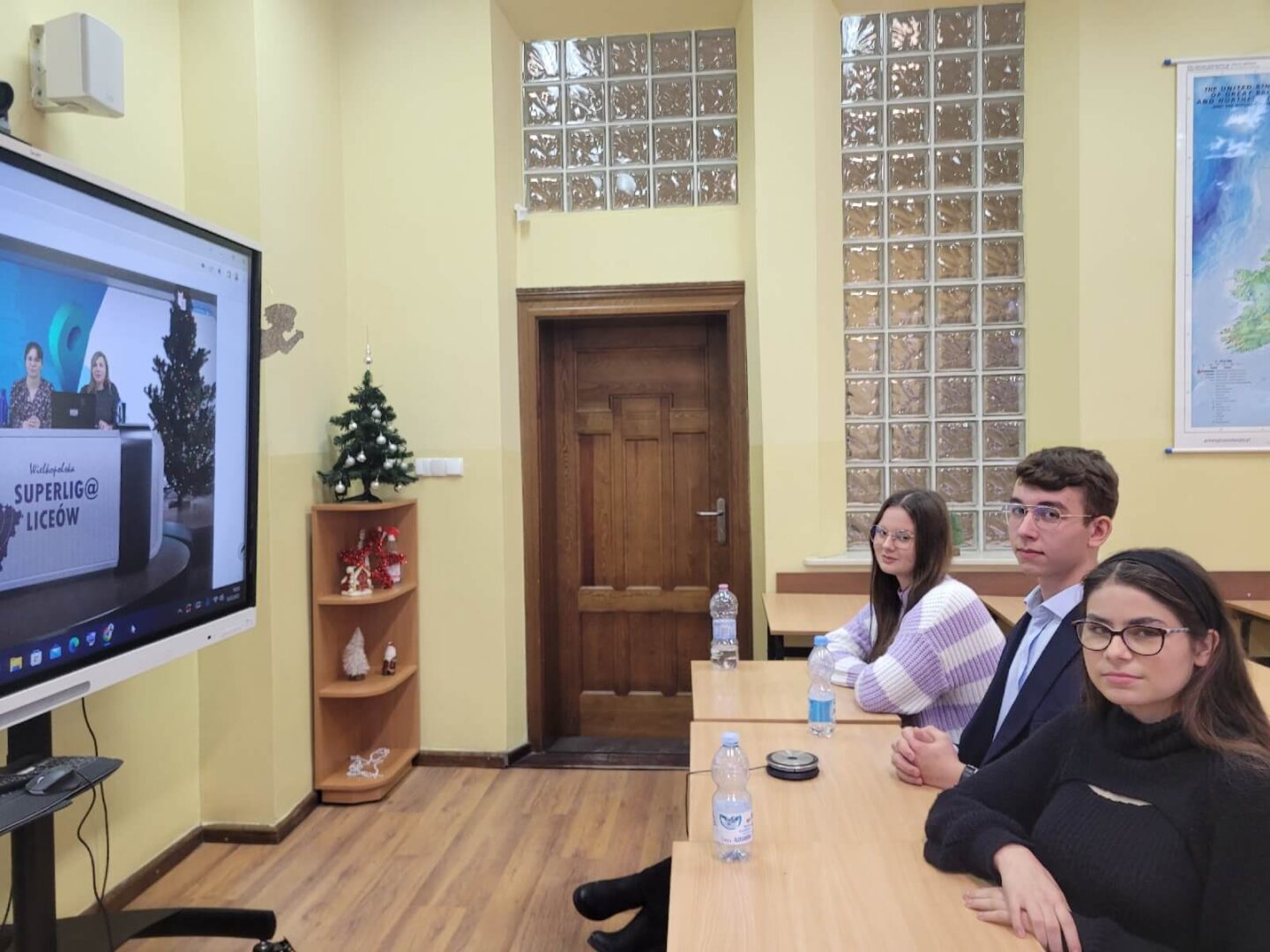 Na zdjęciu uczniowie siedzący przed ekranem, rywalizujący w internetowej lidze wiedzy.