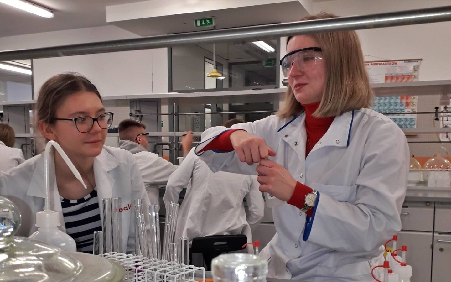 Na zdjęciu uczennice w laboratorium chemicznym, wykonujące doświadczenie.